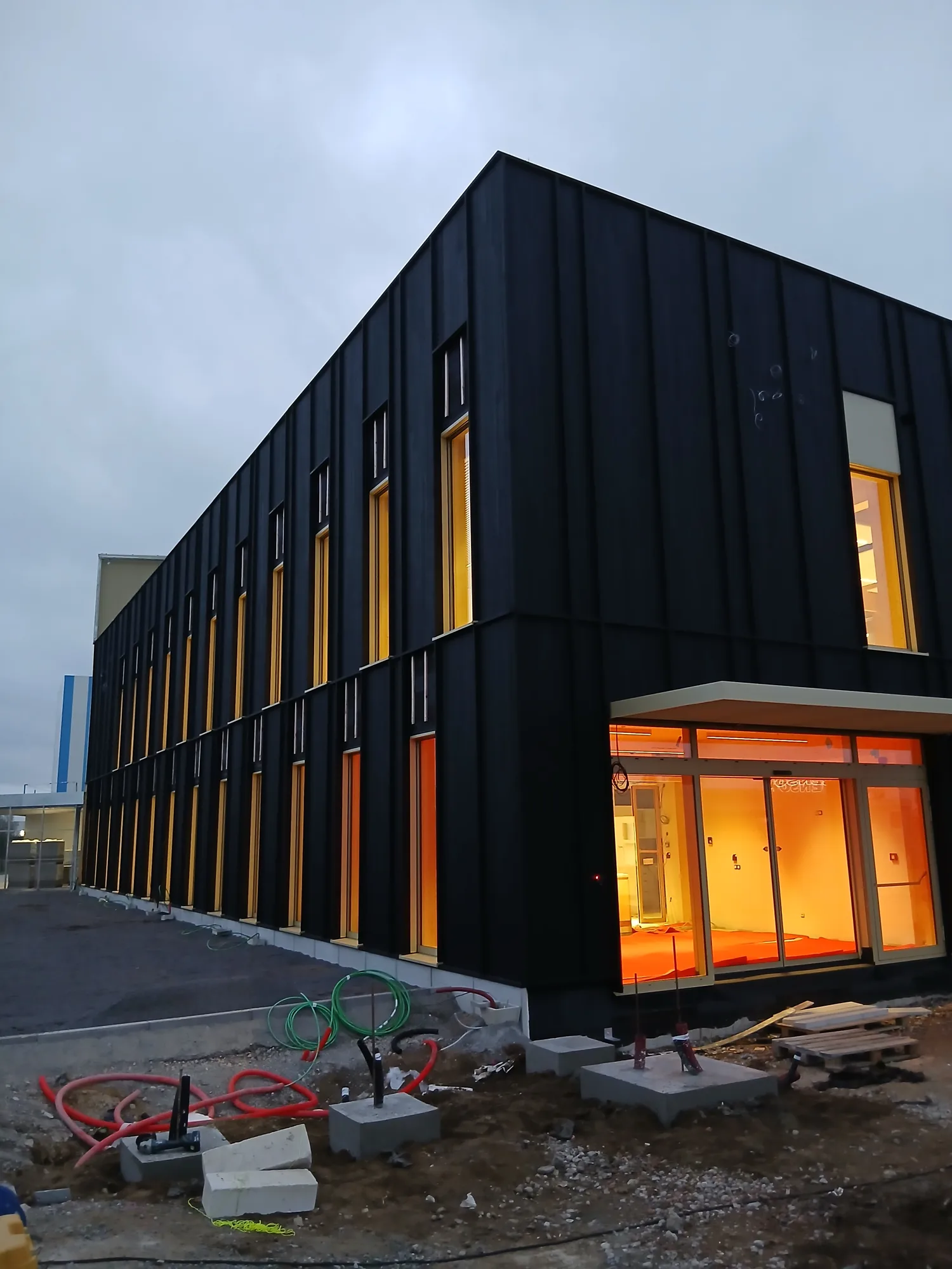 Façade sombre en bardage bois ventilé, immeuble contemporain