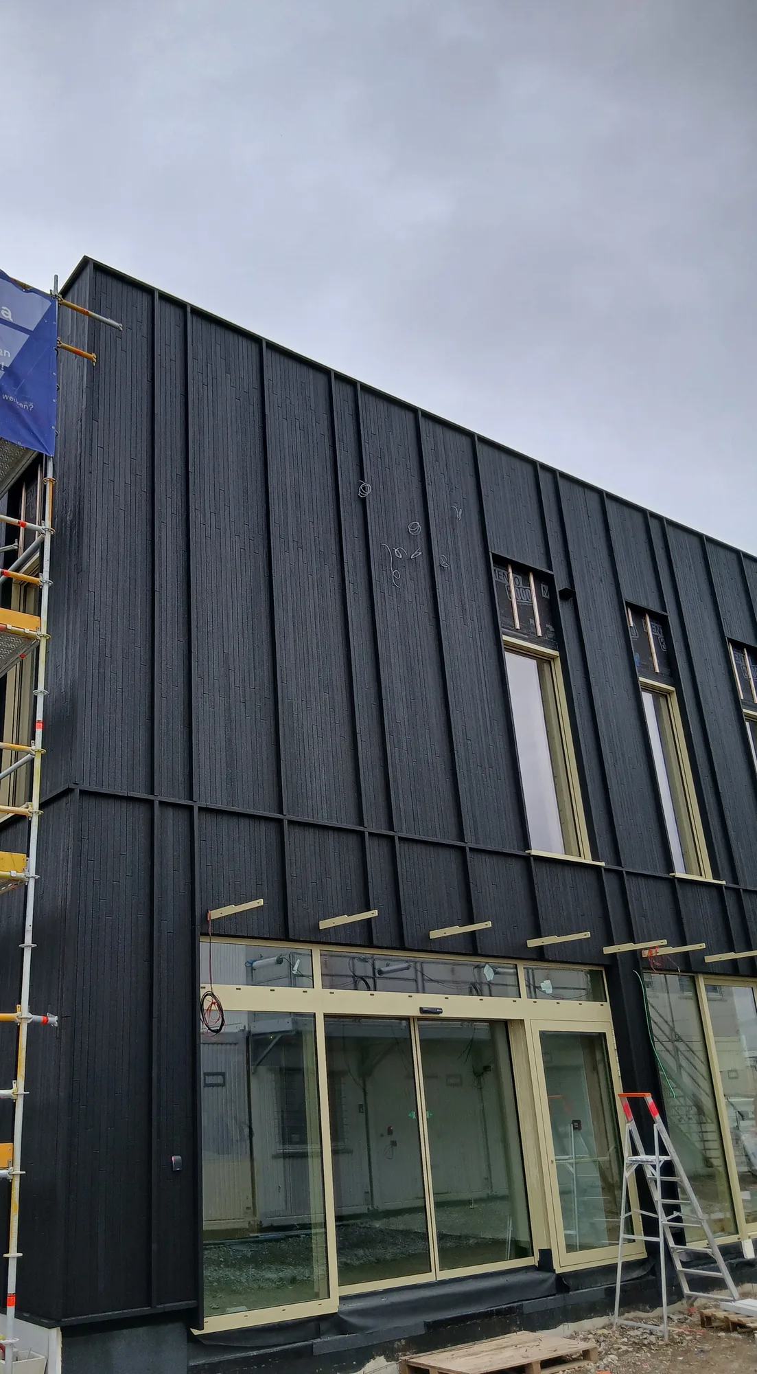 Bâtiment à façade sombre et rez-de-chaussée vitré